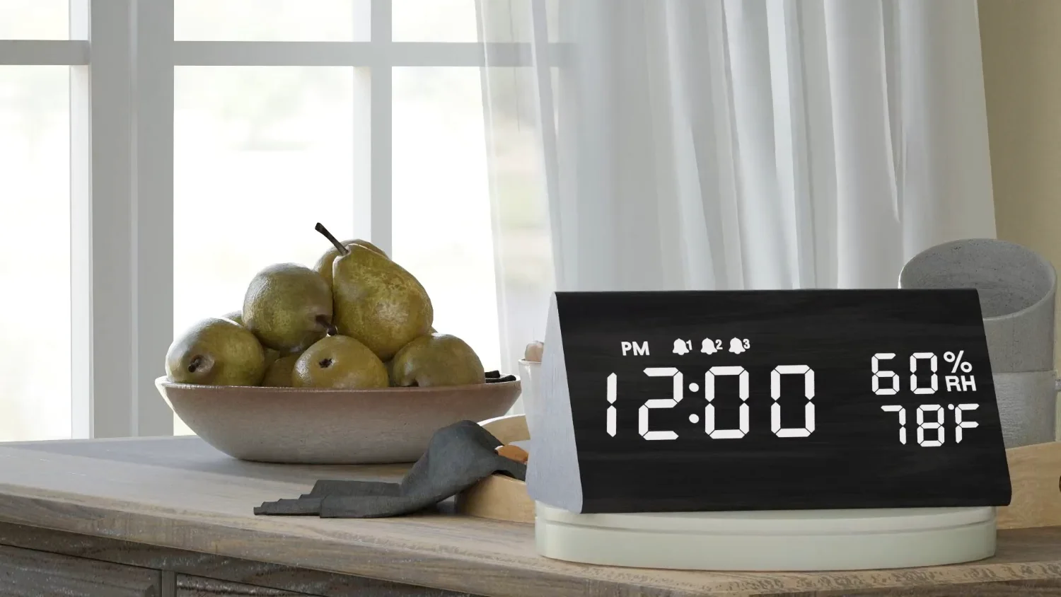 A JALL wooden digital alarm clock beside a bowl of pears